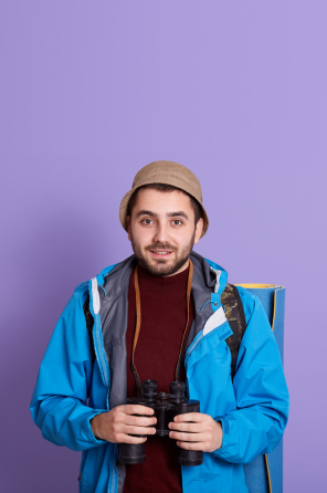  Man in a blue jacket standing confidently, with a purple background